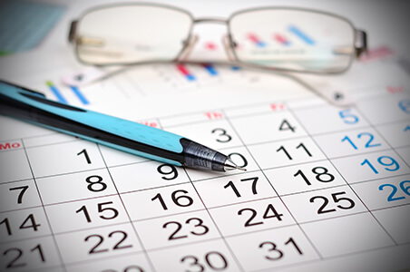 Glasses on calendar with pen